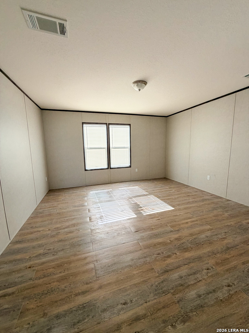309 Jackson Refugio, TX 78377 - Photo 12 of 14 an empty room with wooden floor and windows