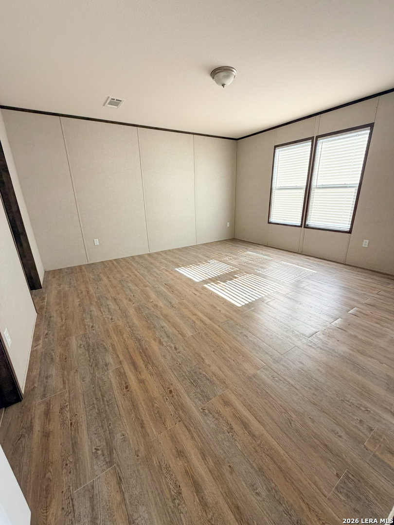 309 Jackson Refugio, TX 78377 - Photo 6 of 14 an empty room with wooden floor and windows