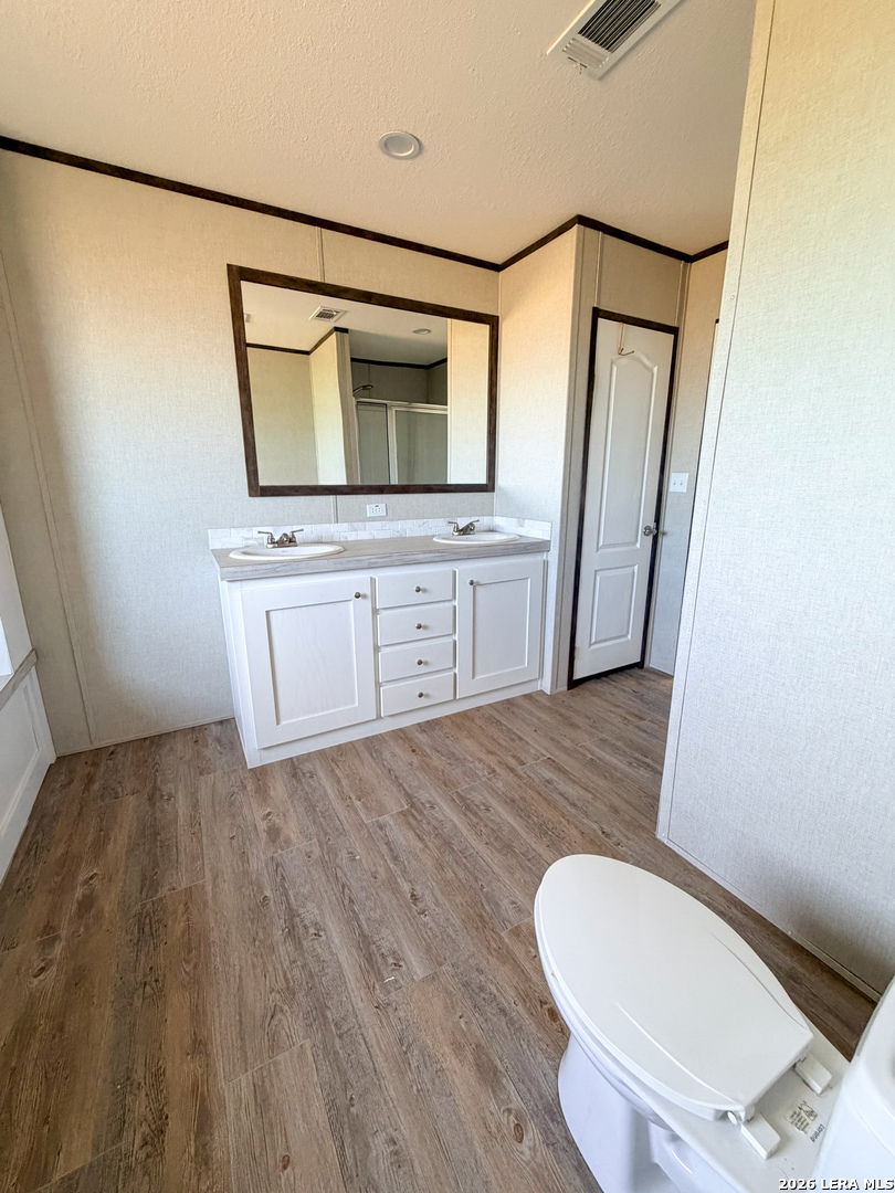 309 Jackson Refugio, TX 78377 - Photo 10 of 14 a bathroom with a toilet mirror vanity and sink