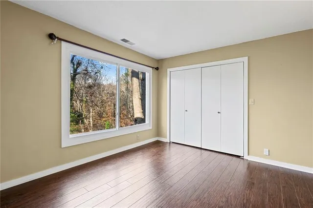 a view of a livingroom with wooden floor and a bathroom