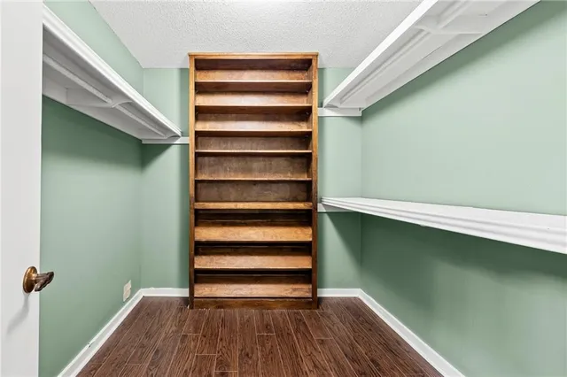 an empty room with wooden floor and natural light