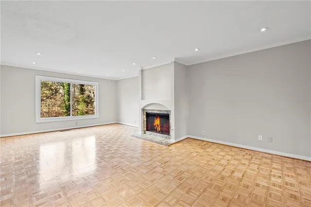 a view of an empty room with a window and fireplace