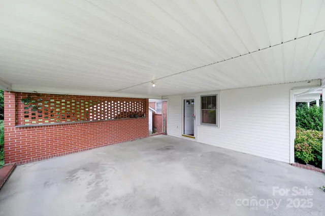 an empty room with windows and fireplace