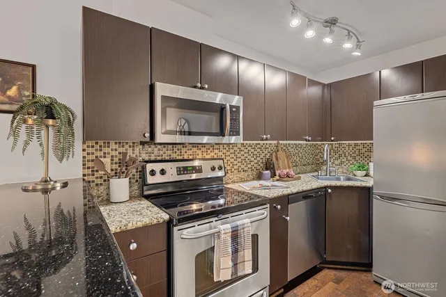 a kitchen that has a sink stainless steel appliances a counter space and cabinets