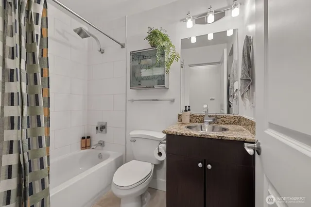 a bathroom with a granite countertop sink toilet and shower