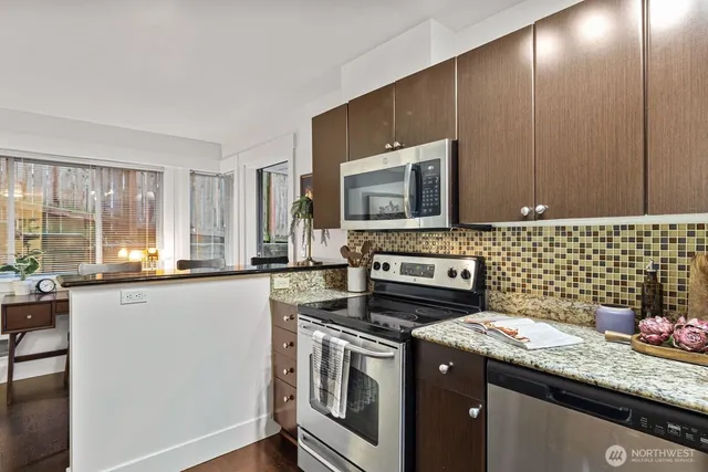 a kitchen with stainless steel appliances a stove a sink and a microwave