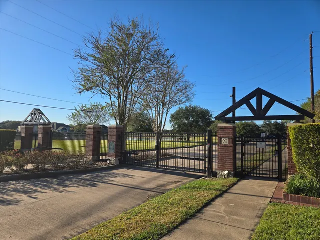 a view of a house with wooden fence next to a yard