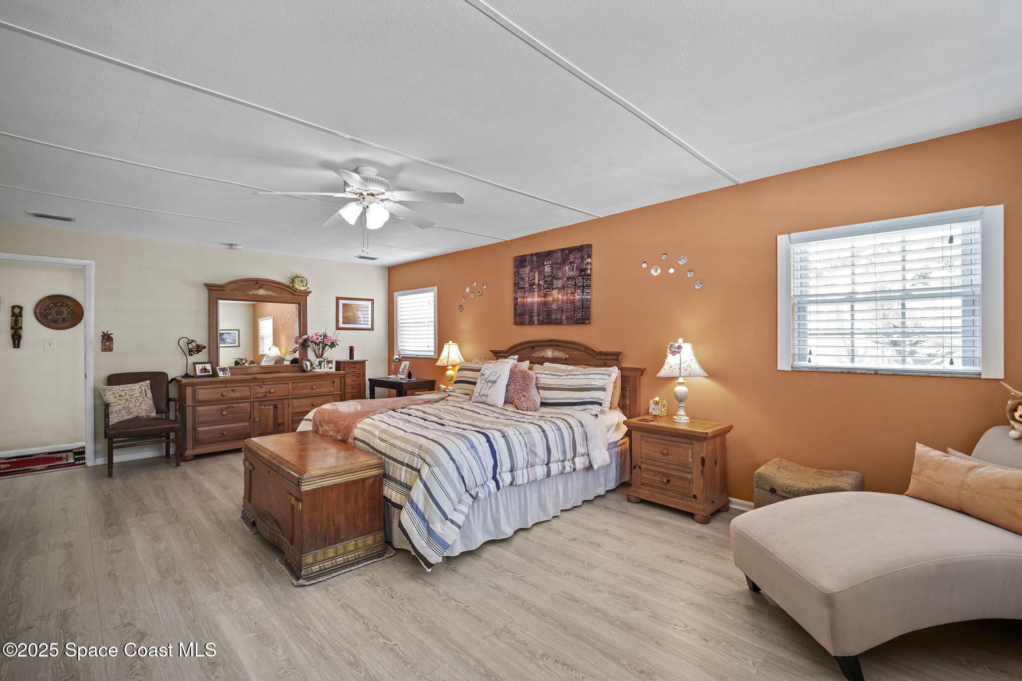 663 Bermuda Road Cocoa Beach, FL 32931 - Photo 17 of 51 a spacious bedroom with a bed couches and a flat tv screen