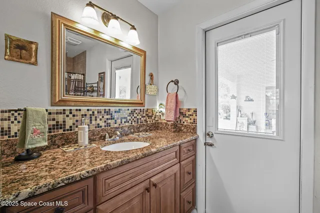 a bathroom with a granite countertop sink a mirror and a window
