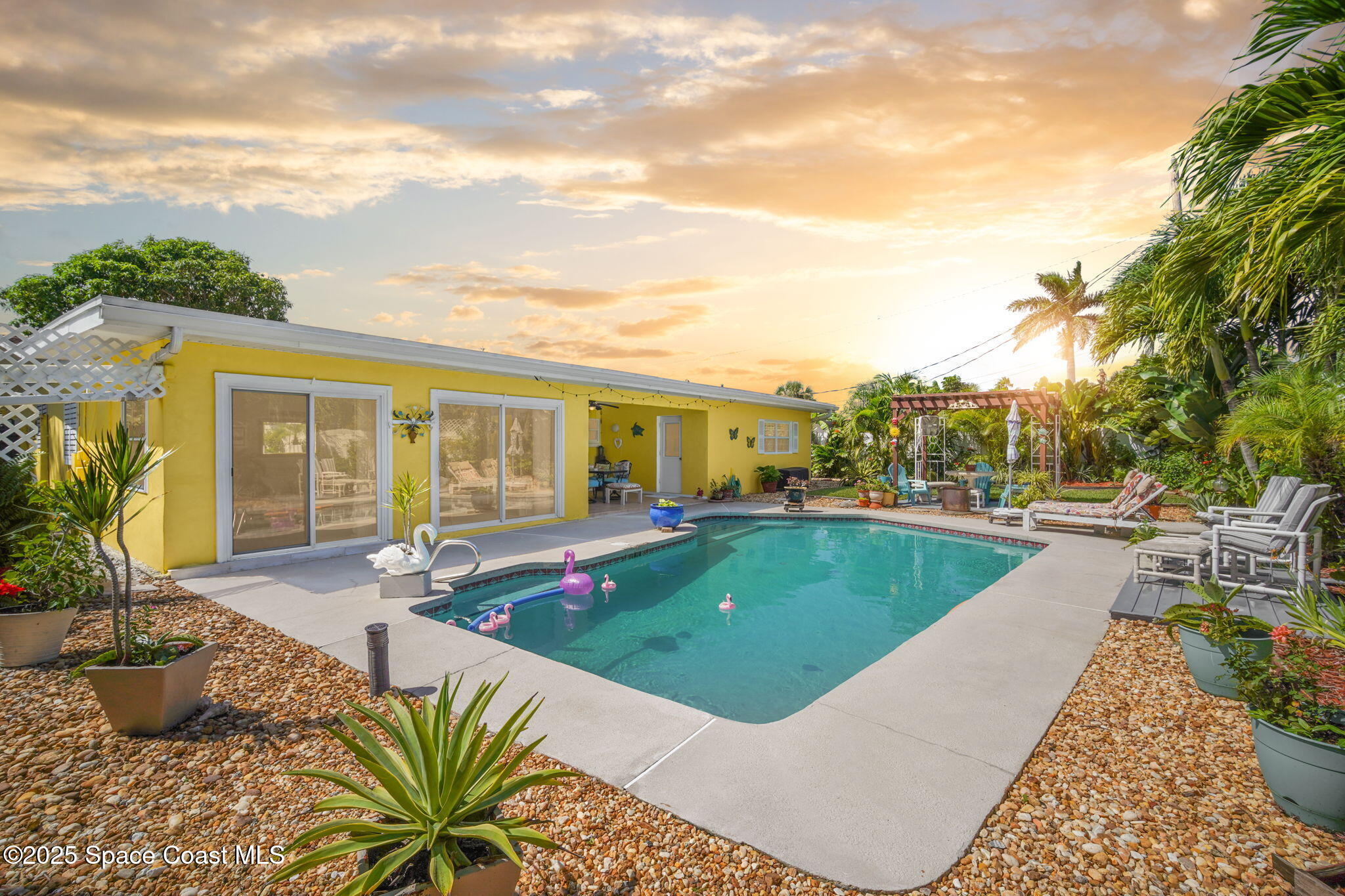 663 Bermuda Road Cocoa Beach, FL 32931 - Photo 2 of 51 a view of a swimming pool with lounge chair