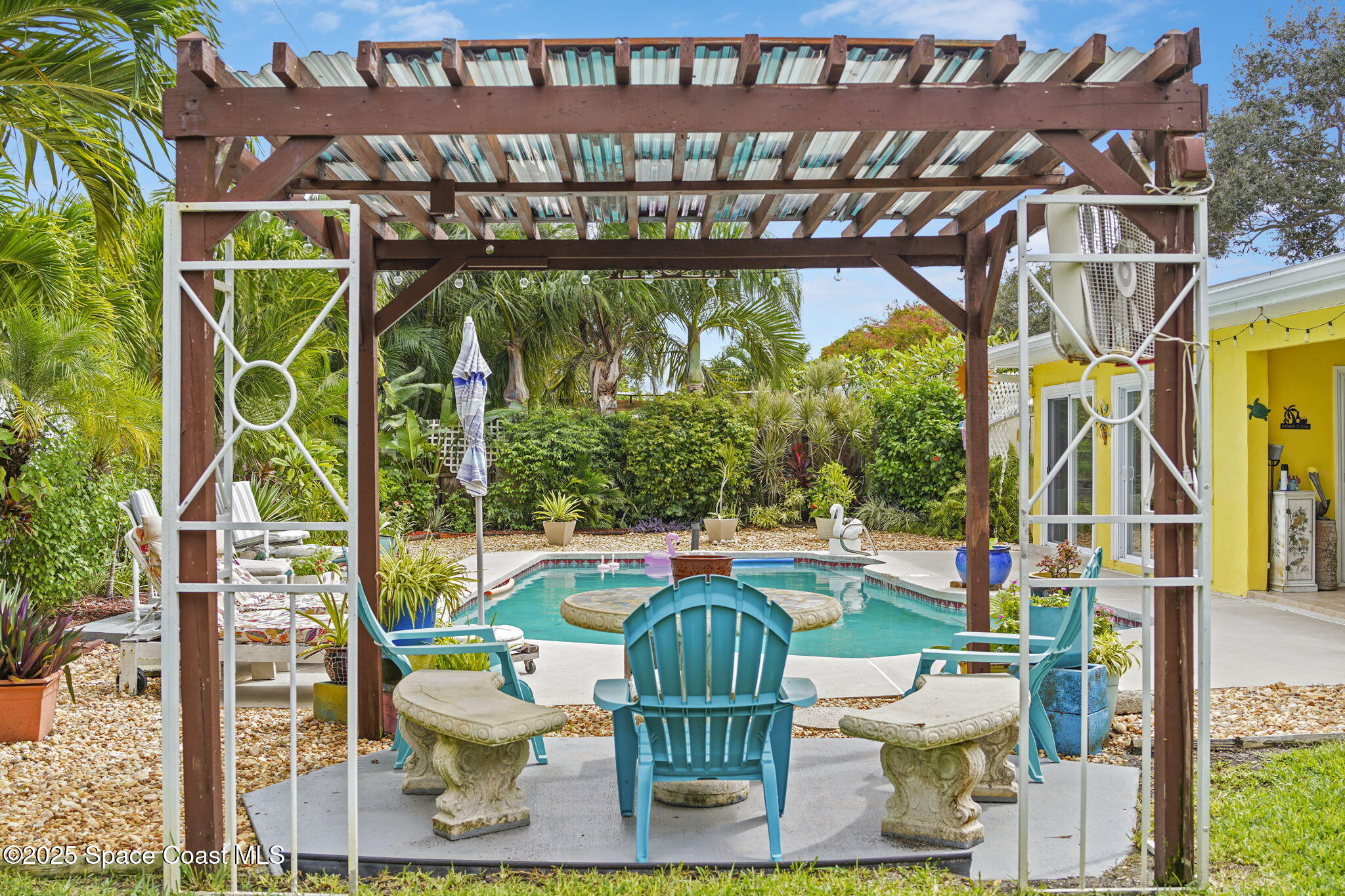 663 Bermuda Road Cocoa Beach, FL 32931 - Photo 33 of 51 a chair and tables in the outdoor space