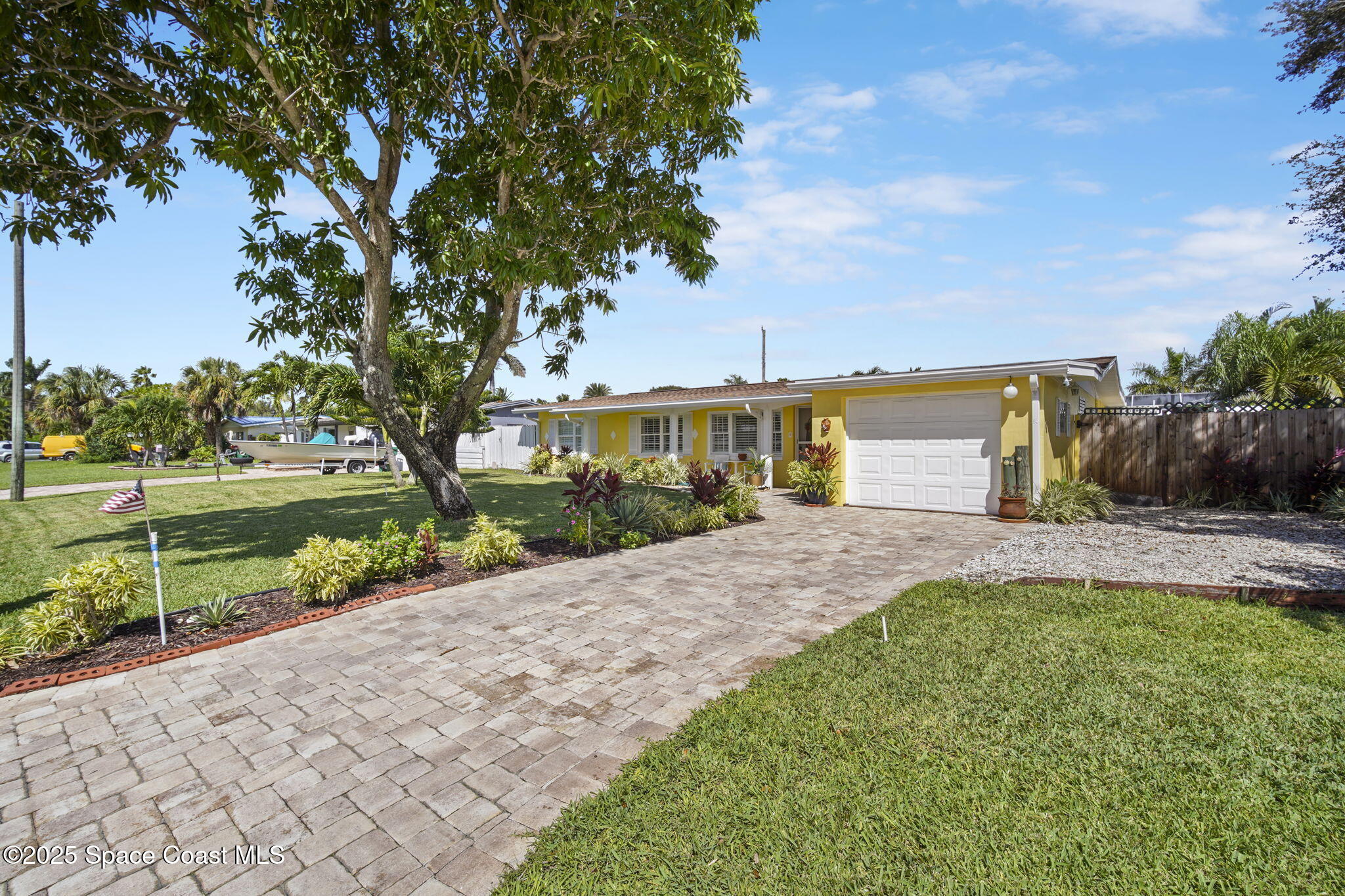 663 Bermuda Road Cocoa Beach, FL 32931 - Photo 39 of 51 a front view of a house with a yard and a garden