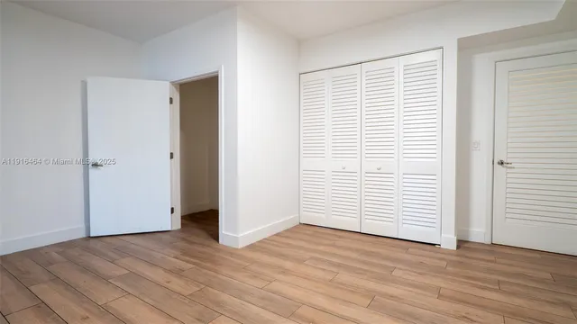 an empty room with wooden floor and white walls
