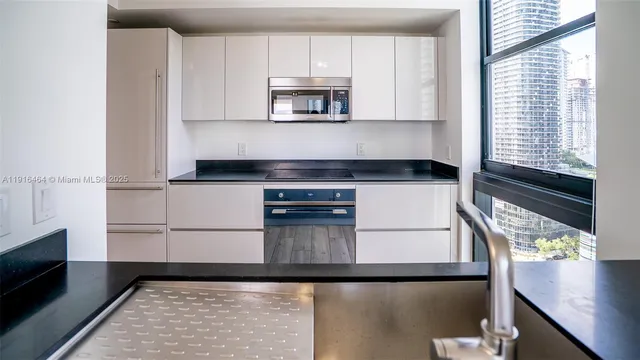 a kitchen with granite countertop a stove a microwave and a refrigerator