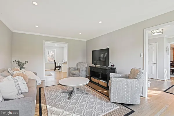 a kitchen with stainless steel appliances granite countertop a stove a sink a dining table and chairs with wooden floor