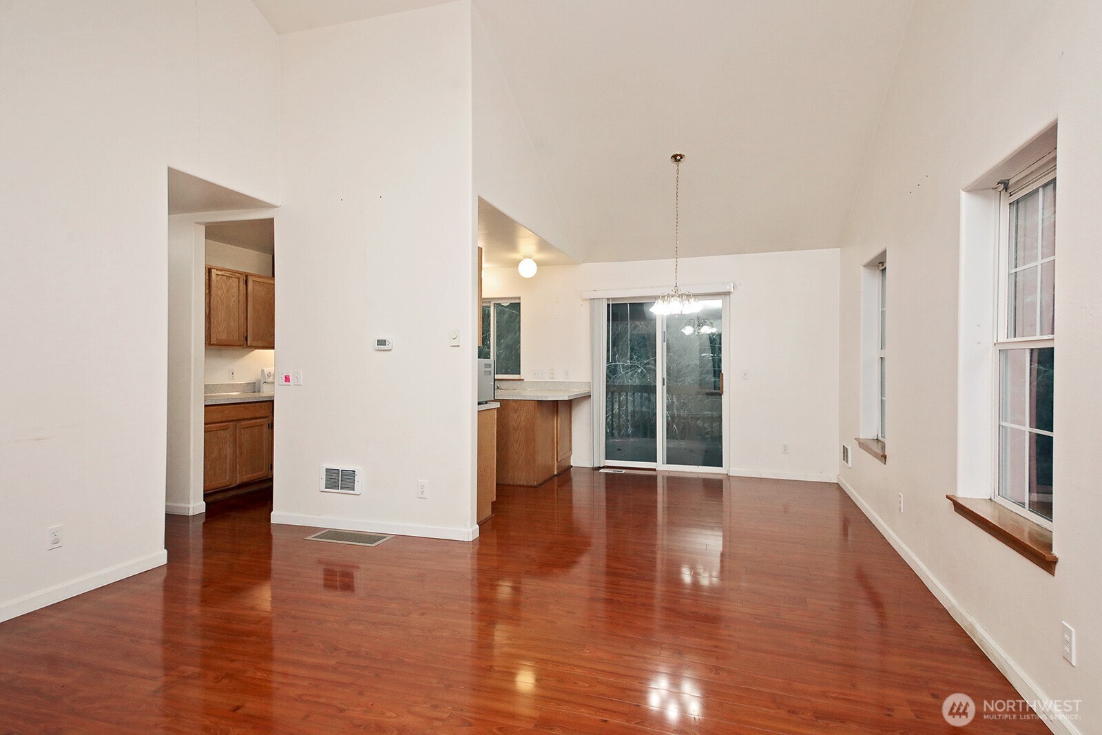 4369 Shadowood Drive Clinton, WA 98236 - Photo 15 of 37 a view of an empty room with wooden floor and a kitchen