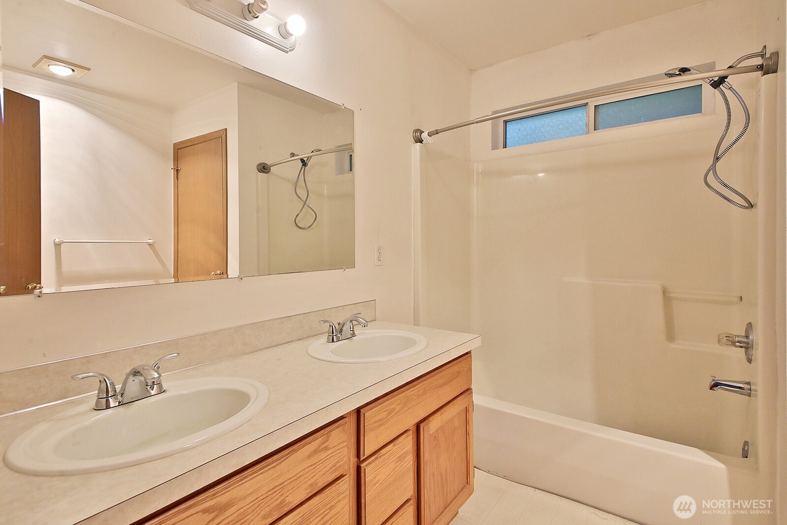4369 Shadowood Drive Clinton, WA 98236 - Photo 36 of 37 a bathroom with a granite countertop sink a mirror a shower and a bathtub