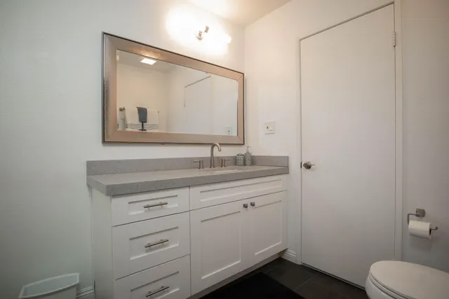 a bathroom with a toilet sink and mirror