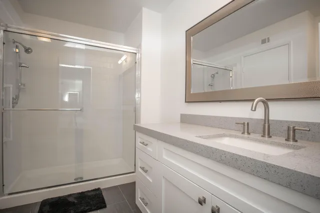 a bathroom with a shower sink and mirror