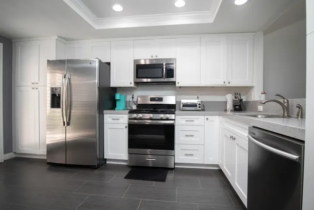 a kitchen with stainless steel appliances granite countertop a refrigerator and a stove