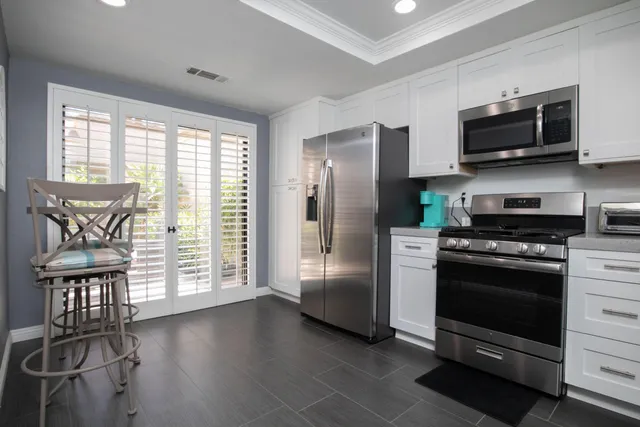 a kitchen with stainless steel appliances a stove a refrigerator and a microwave