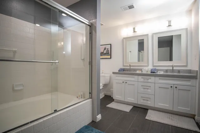 a bathroom with a granite countertop sink mirror bathtub and shower
