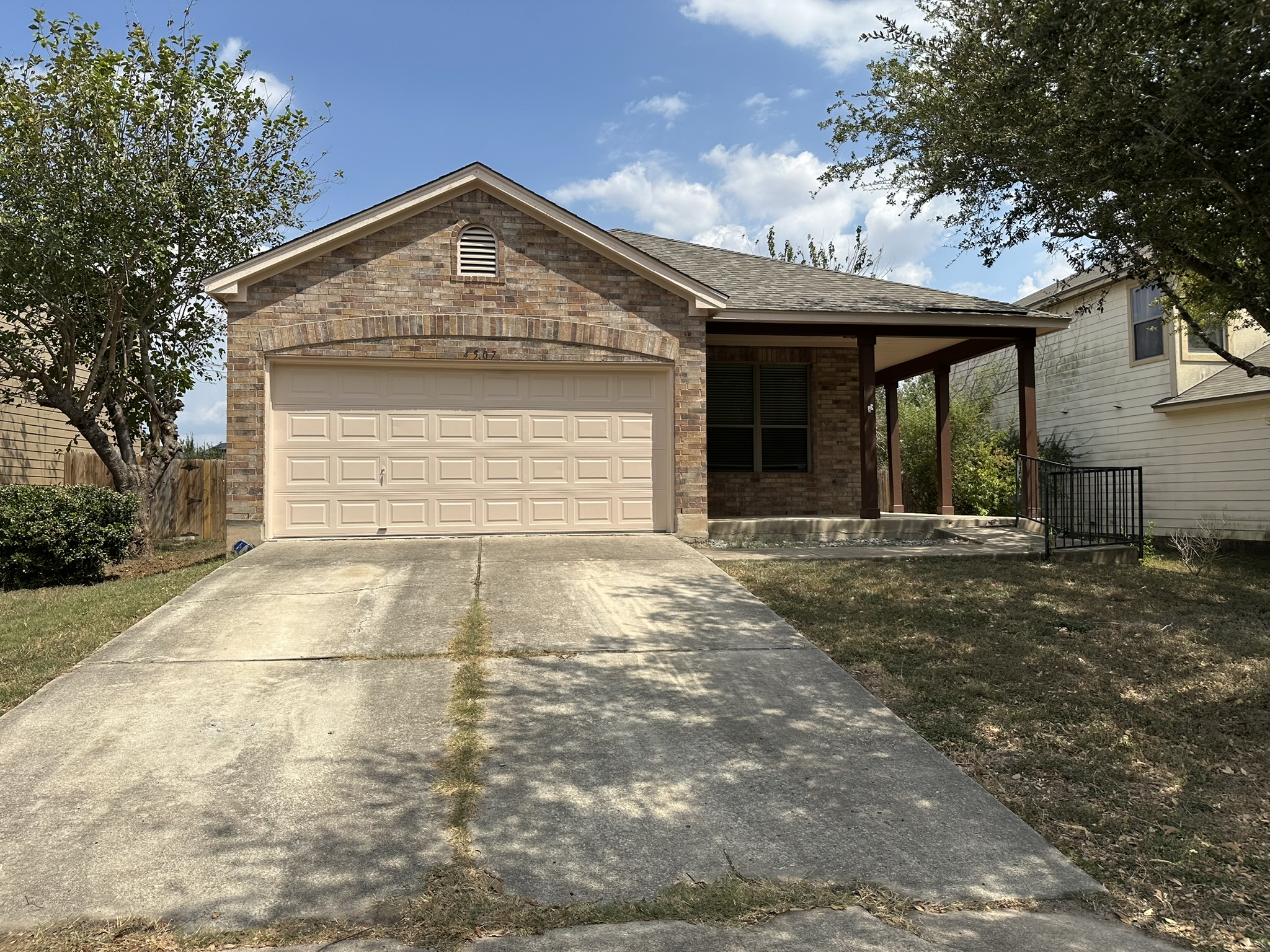 4507 Peach Grove Road Austin, TX 78744 - Photo 34 of 35 A classic brick exterior and concrete driveway lead to the welcoming covered front porch.