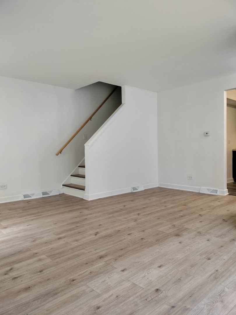 7910 South Muskegon Avenue, Unit 1 Chicago, IL 60617 - Photo 18 of 21 a view of an empty room with wooden floor