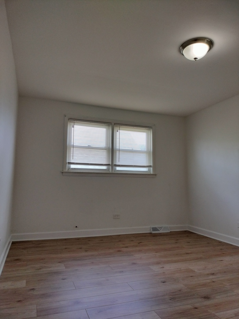 7910 South Muskegon Avenue, Unit 1 Chicago, IL 60617 - Photo 7 of 21 a view of a room that has wooden floor and window