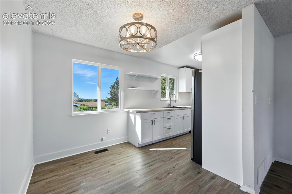7033 Sequoyah Way Colorado Springs, CO 80915 - Photo 7 of 20 a view of a kitchen cabinets and wooden floor