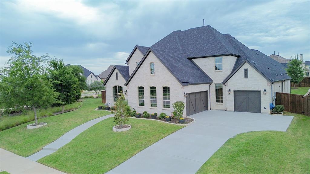 1316 Limestone Ridge Road Mansfield, TX 76063 - Photo 35 of 40 Contemporary two-story residence featuring light-colored brick exterior, dark shingle roofing, and a concrete driveway
