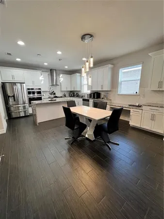 a living room with granite countertop furniture a dining table wooden floor and a fireplace