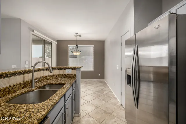 a kitchen with granite countertop a refrigerator and a sink
