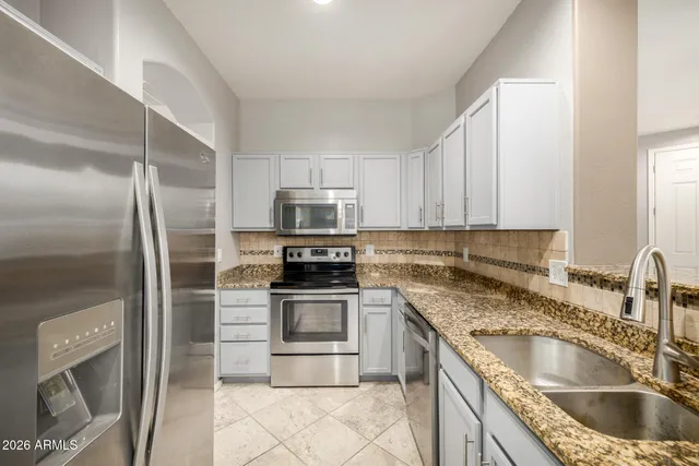a kitchen with stainless steel appliances granite countertop a sink stove and refrigerator