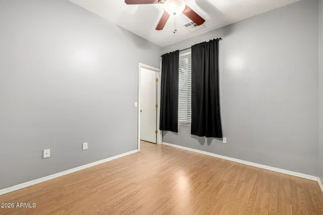 a view of an empty room with wooden floor