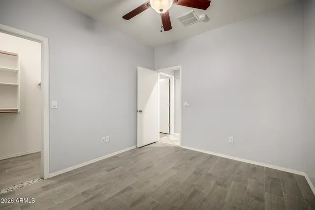 an empty room with a ceiling fan and carpet