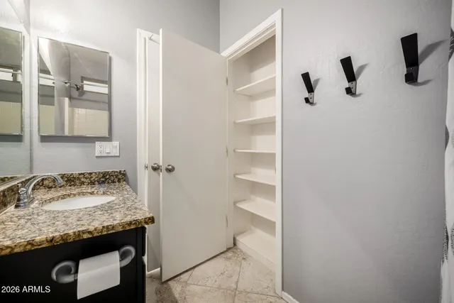 a bathroom with a granite countertop sink and a mirror