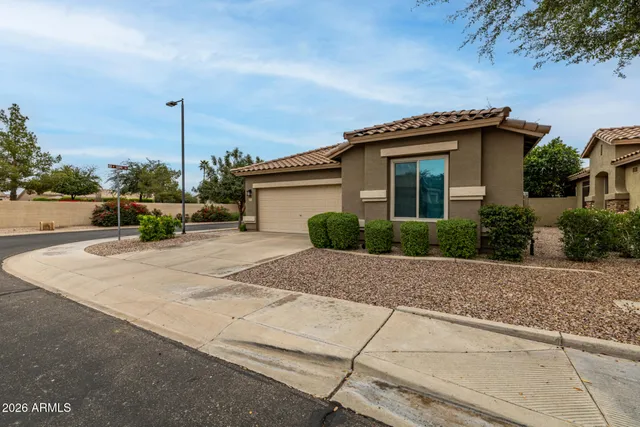 a yellow house with a flower garden in front of it