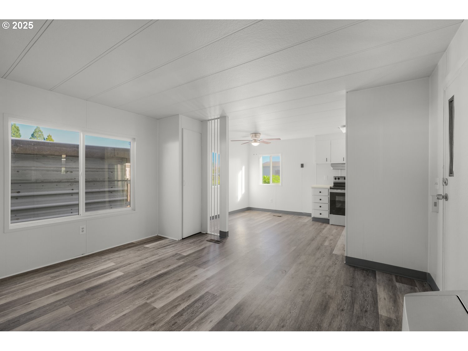 5355 River Road North, Unit 85 Keizer, OR 97303 - Photo 4 of 25 a view of an empty room with wooden floor and a window