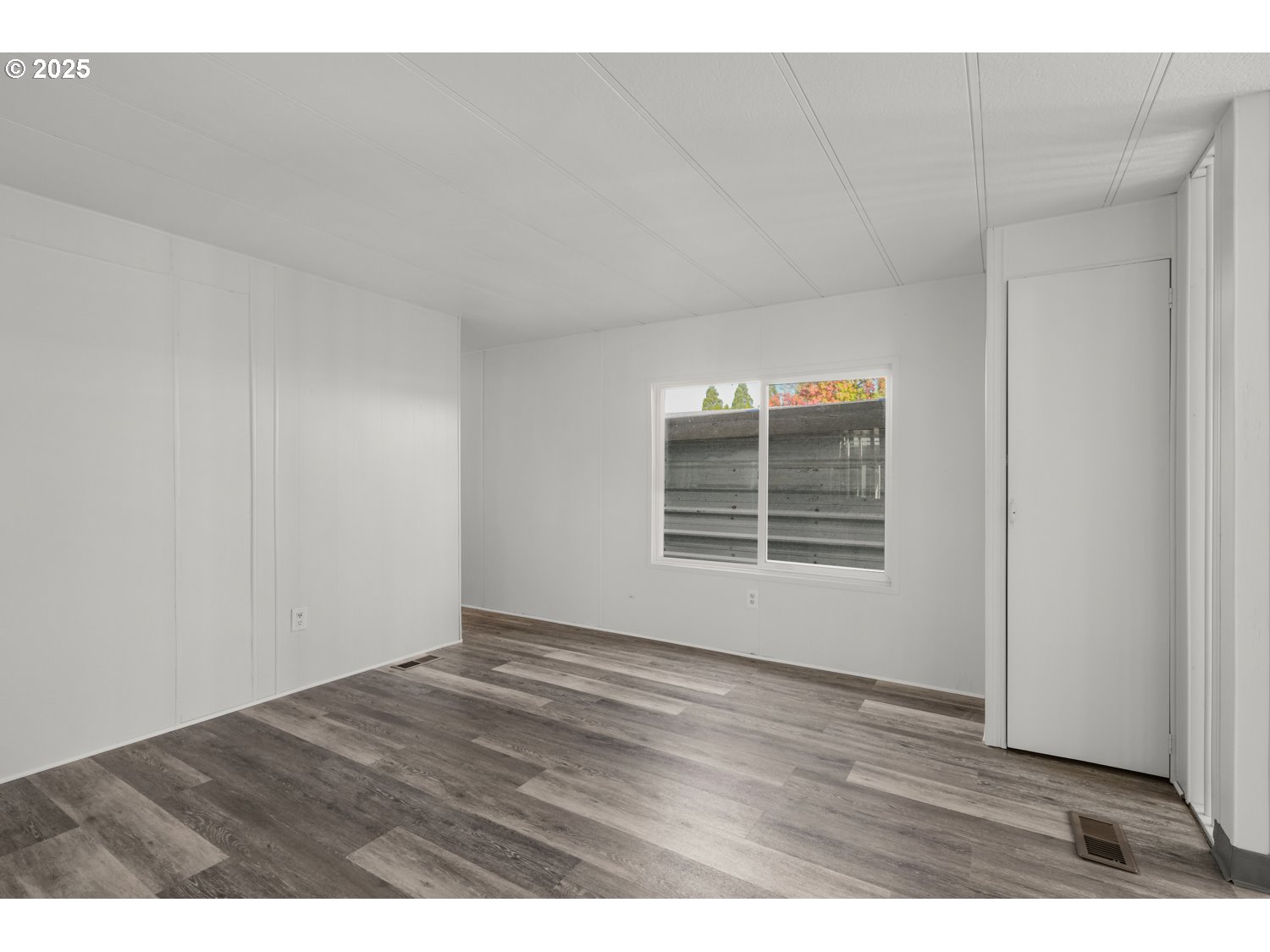 5355 River Road North, Unit 85 Keizer, OR 97303 - Photo 5 of 25 a view of an empty room with wooden floor and a window