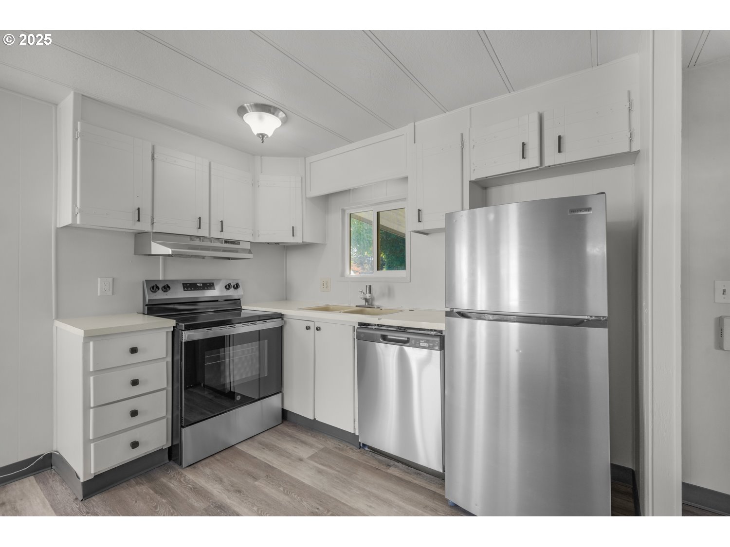 5355 River Road North, Unit 85 Keizer, OR 97303 - Photo 7 of 25 a kitchen with stainless steel appliances white cabinets and a refrigerator