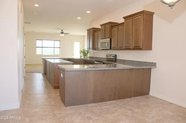 a kitchen with stainless steel appliances granite countertop a sink and a refrigerator