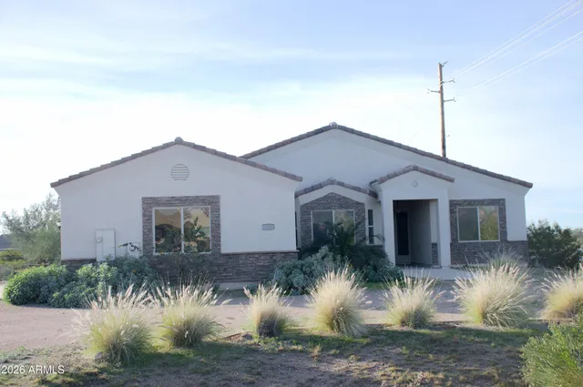 a front view of house with a yard and potted plants