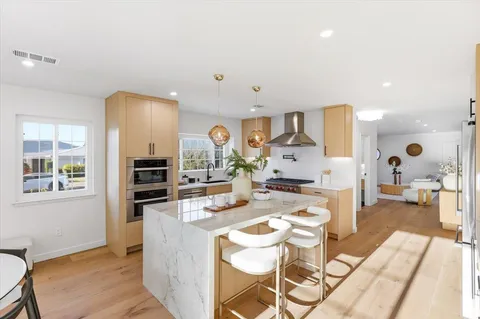 a living room with stainless steel appliances kitchen island granite countertop furniture and a view of kitchen