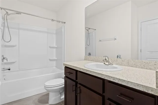 a bathroom with a granite countertop sink toilet a shower and a mirror