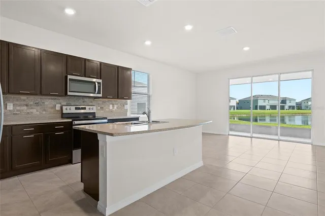 a kitchen with stainless steel appliances a stove a sink and a microwave