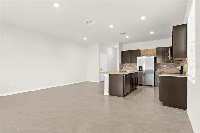 a large kitchen with a large counter top stainless steel appliances and cabinets