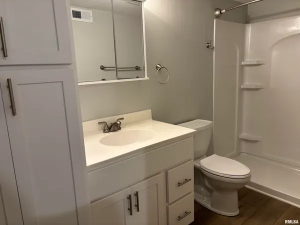 a bathroom with a sink a toilet and shower