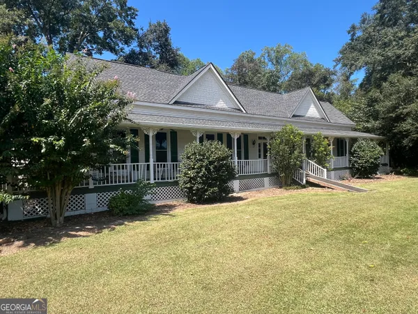 a view of a house with backyard and sitting area