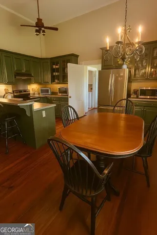 a kitchen with a table chairs refrigerator and microwave